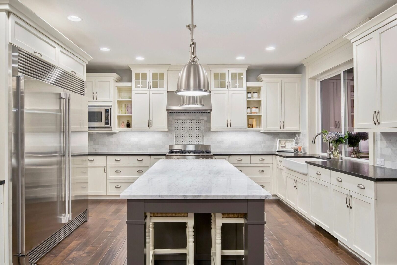 A kitchen with white cabinets and a center island.